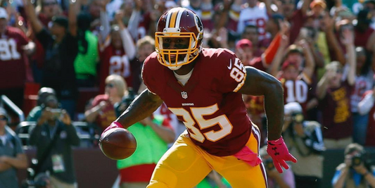 Football player in burgundy and gold #85 running with the ball in a crowded stadium