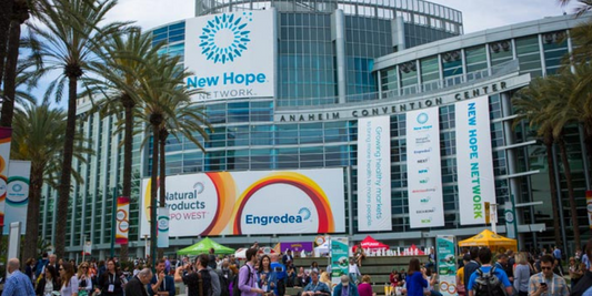 People gathered outside the Anaheim Convention Center with large banners reading Natural Products Expo West and New Hope Network