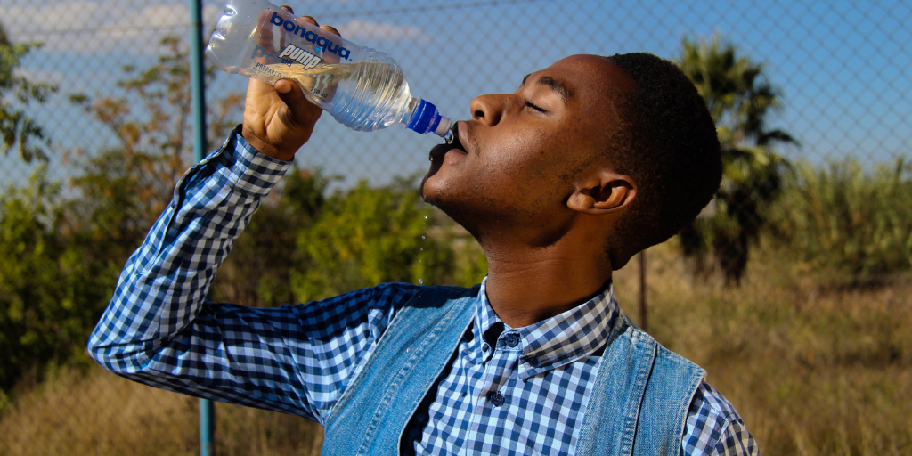 Fish trapped inside a crushed single-use plastic bottle, illustrating plastic pollution