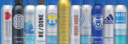 Front view of custom-branded reusable aluminum water bottles showing printed logos and colored metallic finishes
