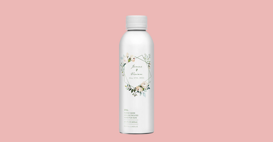 Front view of PATH custom aluminum bottle showing floral wedding label reading James & Vivian, May 27, 2024 on pink background