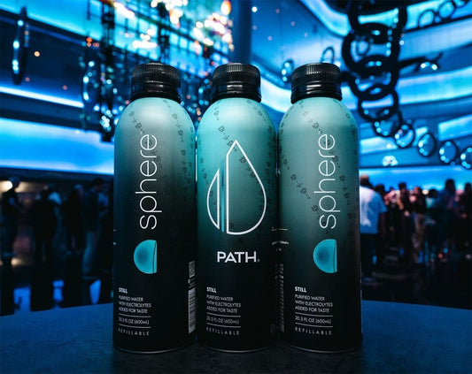 Front view of three PATH x Sphere aluminum bottles showcasing PATH logo and refillable label with blue-lit event crowd in background