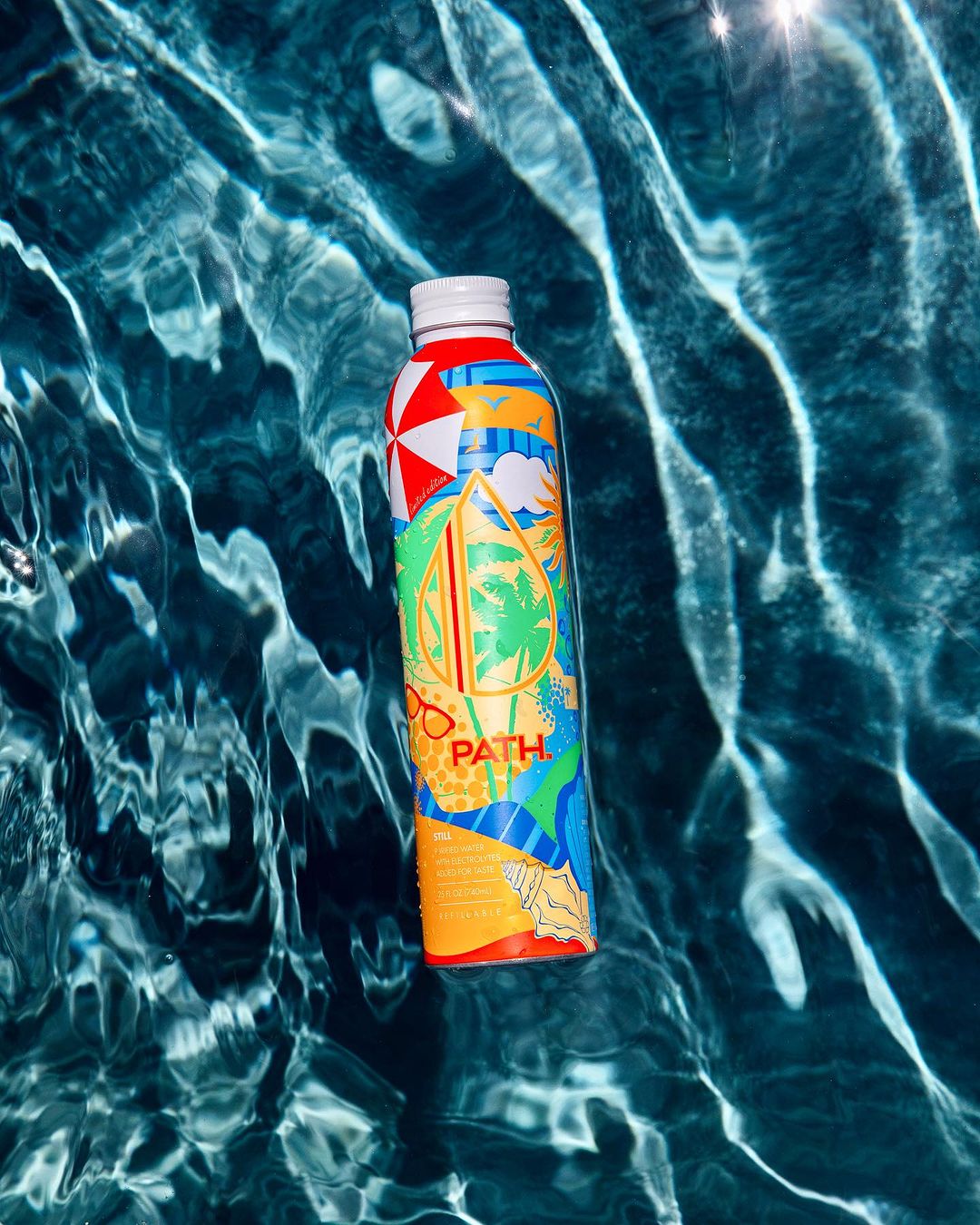 Front view of PATH water bottle showcasing colorful tropical graphic design floating on rippling pool water