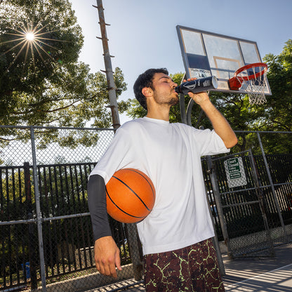 man playing basketball drinking an alkaline path water bottle