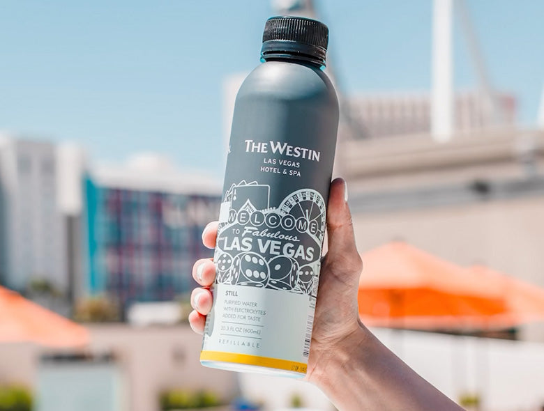 Close-up of a PATH aluminum bottled water bottle showcasing custom Westin Las Vegas branding outdoors