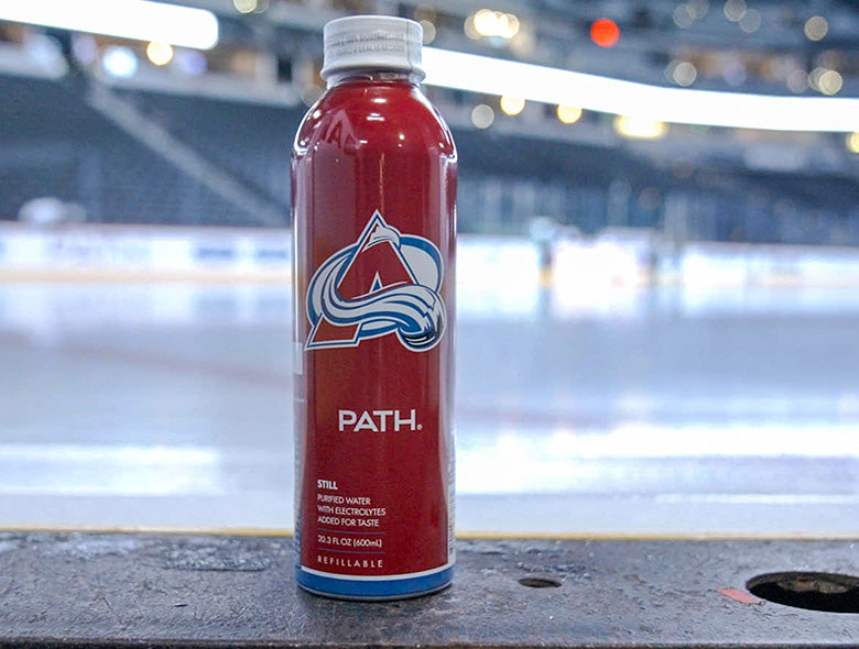 Front view of a red PATH bottled water bottle showcasing custom full bottle printing with an arena background