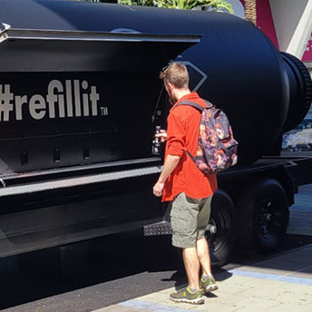 Person approaches the PATH refill trailer carrying a backpack
